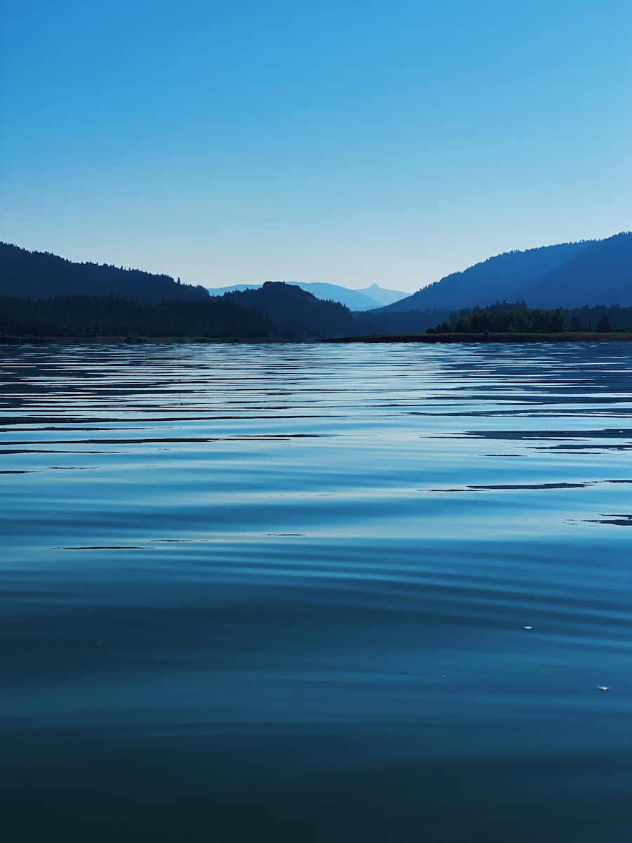body of water near mountain during daytime
